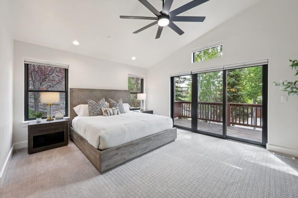 Spacious primary bedroom with new carpet and large windows overlooking Jordanelle Reservoir