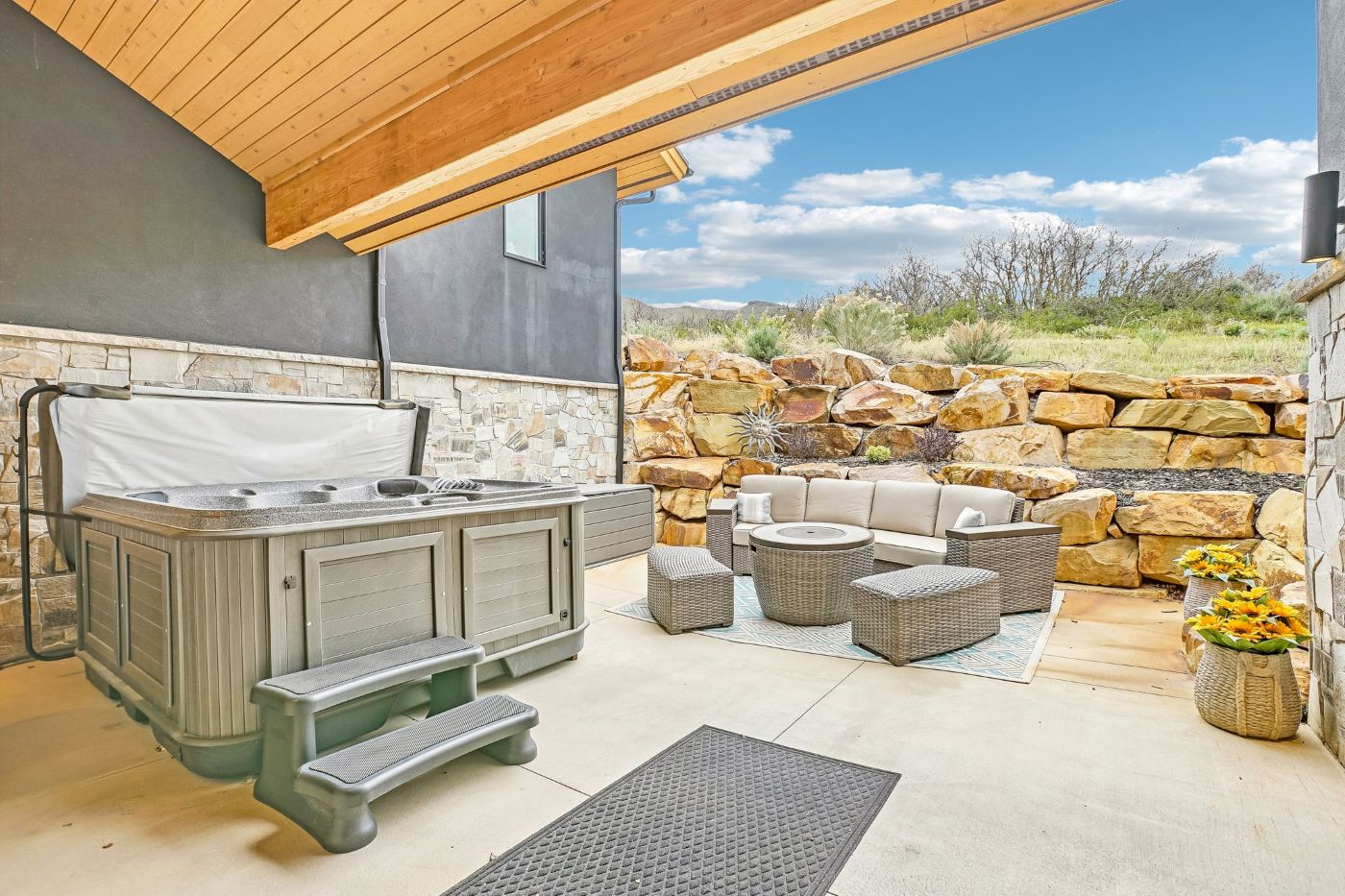 Private outdoor patio with hot tub and seating area backing to open space in Soaring Hawk at Hideout
