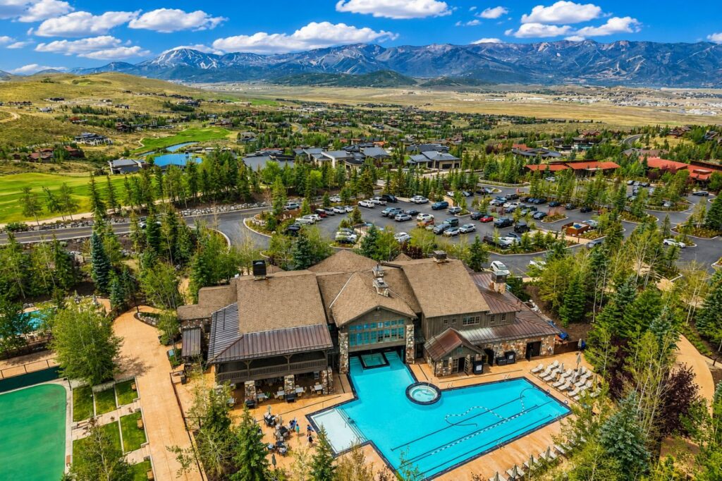 Aerial view of the Promontory Club tennis courts, clubhouse, swimming pool, and surrounding mountain views in Park City, Utah.