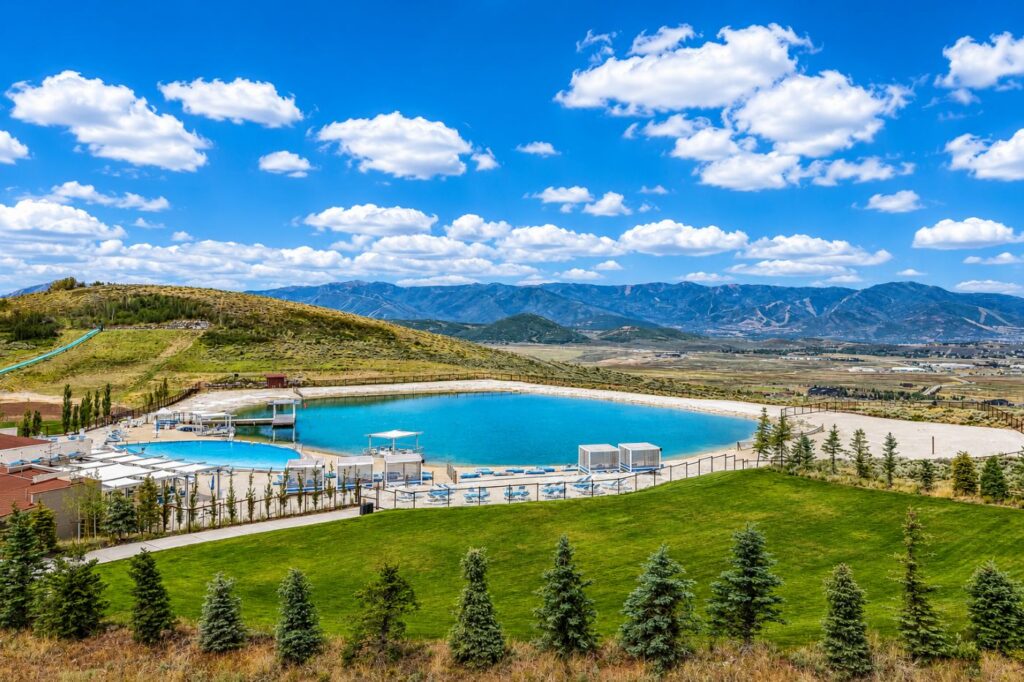 The Promontory Beach Club features swimming pool, lake, sandy beach, family recreation, and mountain views in Park City, Utah.