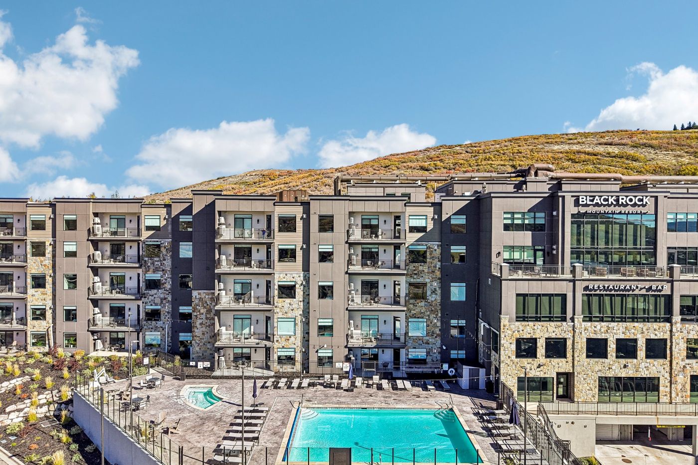 Exterior view of Black Rock Mountain Resort near Park City, Utah, featuring the resort's heated outdoor swimming pool and contemporary mountain architecture.