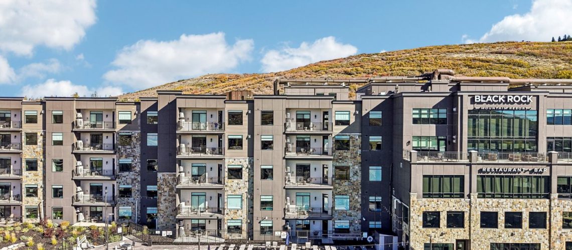 Exterior view of Black Rock Mountain Resort near Park City, Utah, featuring the resort's heated outdoor swimming pool and contemporary mountain architecture.